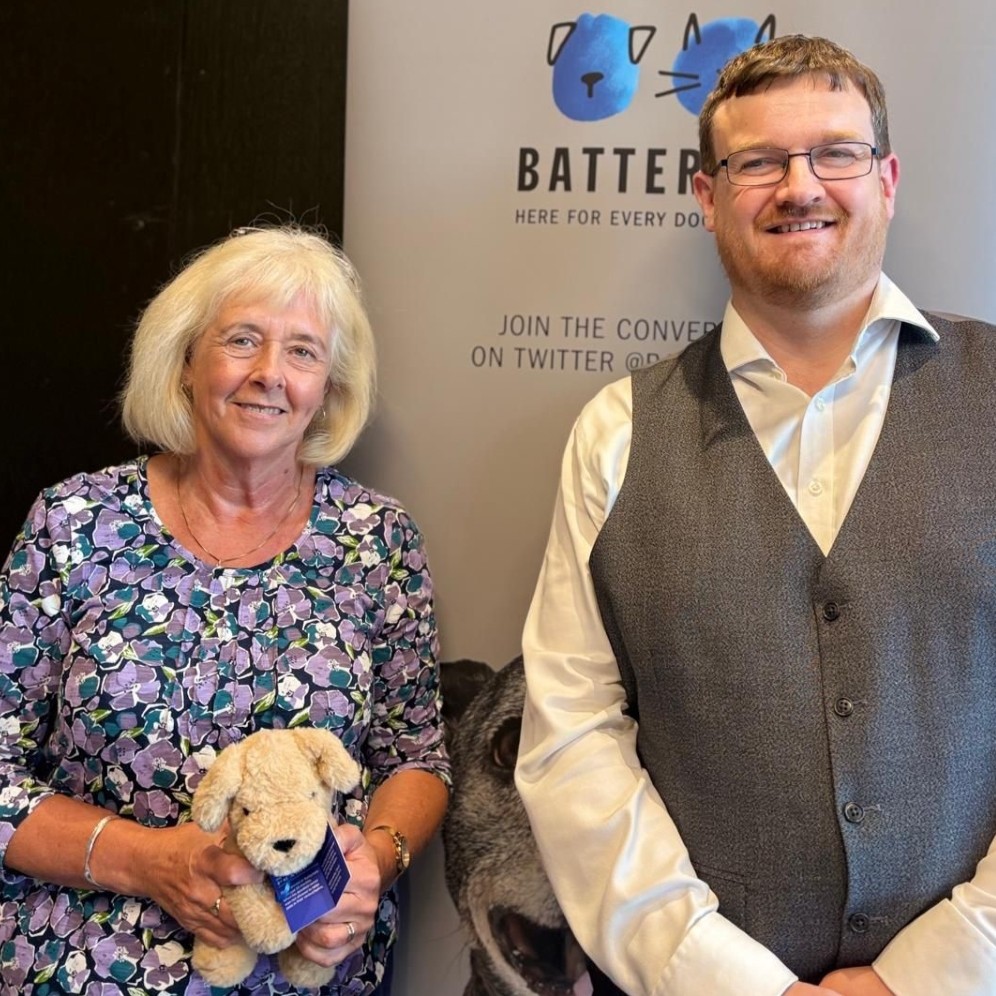 An MP and a Battersea employee standing in front of a Battersea banner